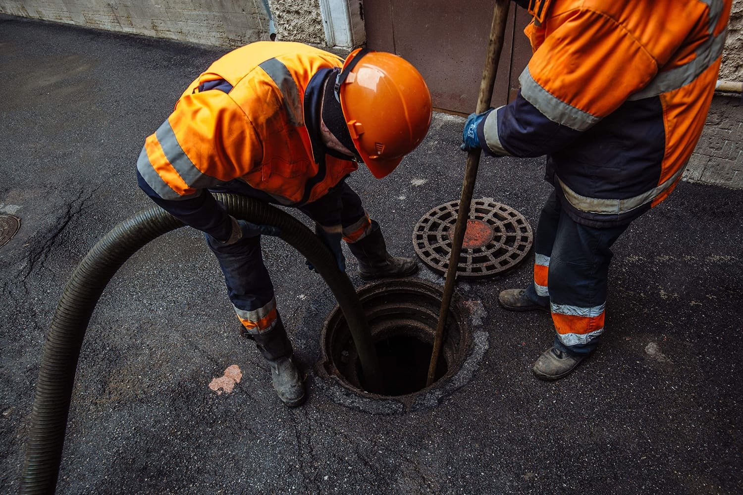 Crew clearing and maintaining a sewer manhole on a Brisbane street